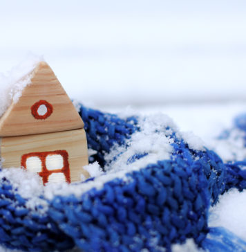 Haus in der Schneelastzone, mit einem wärmenden Schal und Schnee