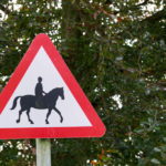 Achtung Pferde Schild vor einem Baum